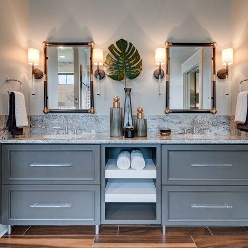 A bathroom with two sinks and a mirror in a custom home for sale in Westfield, Indiana.