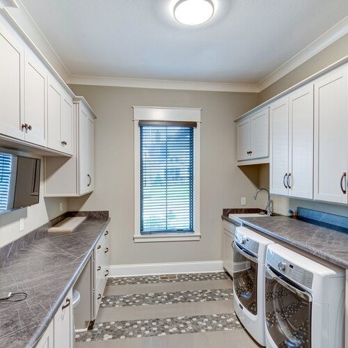 A modern laundry room featuring a washer and dryer, conveniently located in new homes for sale in Carmel, Indiana.