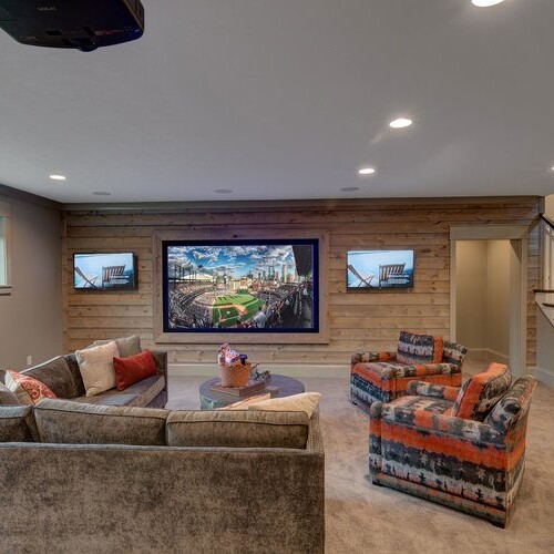 A living room with a television, couches and stairs in a new home construction in Carmel, Indiana.
