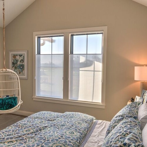 A bedroom with a hanging bed and a window in a custom home in Westfield, Indiana.