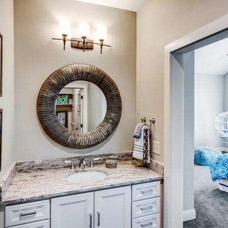 A blue and white bathroom with a mirror, perfect for new homes for sale in Carmel, Indiana.