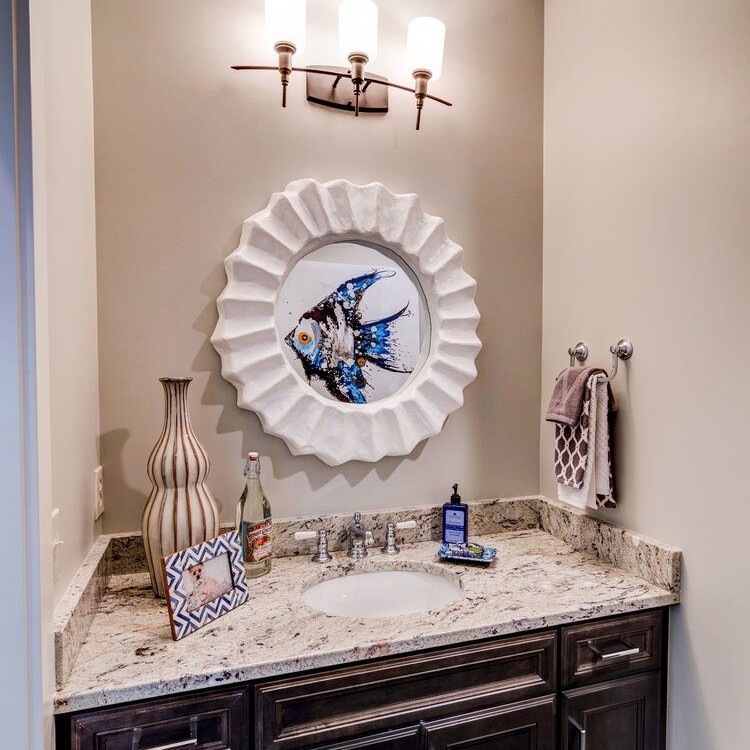A bathroom with a sink and a mirror above it, located in a new home for sale in Carmel, Indiana.