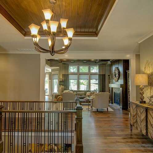 A hallway with custom hardwood floors, adorned with a stunning chandelier.