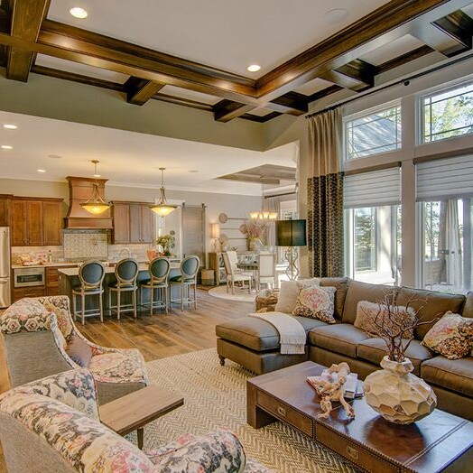 An elegantly designed living room with hardwood floors and wood ceilings, showcasing the craftsmanship of our custom home builder in Carmel, Indiana.