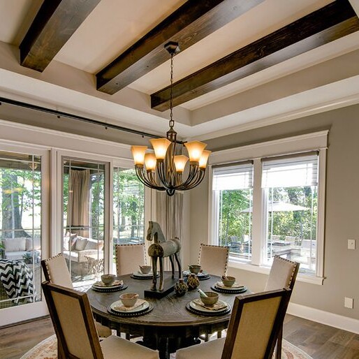 A dining room with hardwood floors and wood beams in a new home construction in Indianapolis Indiana.