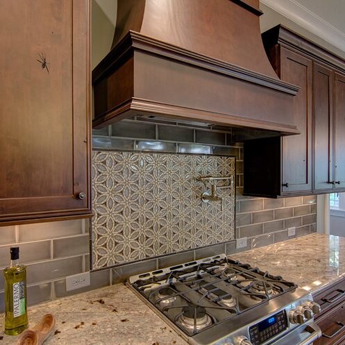 A kitchen with brown cabinets and a stove in a new home for sale in Carmel, Indiana.