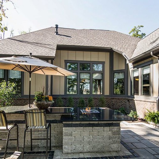 A patio with a fire pit and patio furniture, designed by a custom home builder in Carmel, Indiana.