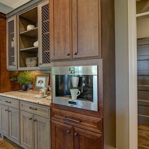 A kitchen with wood cabinets and a microwave, designed by a luxury custom home builder in Indiana.