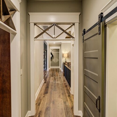 Luxury custom home builder Westfield Indiana creates a stunning hallway with a sliding barn door.