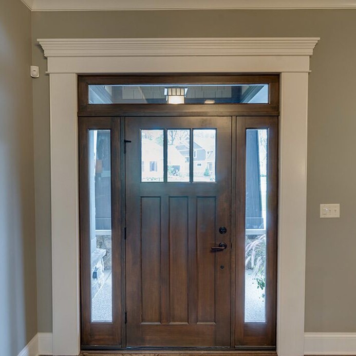 A front door in a custom home with hardwood floors.