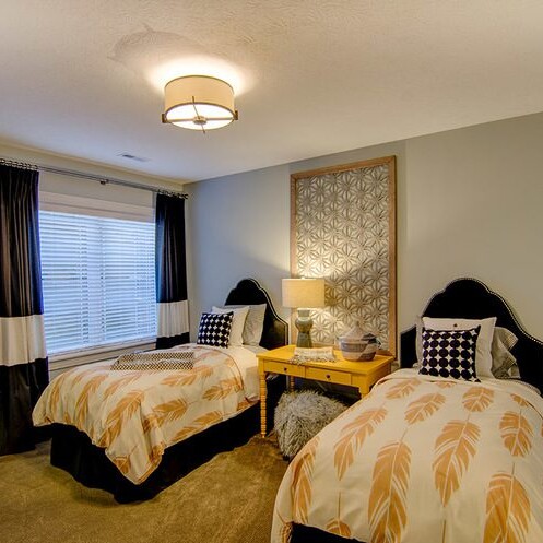 Two twin beds in a bedroom with a ceiling fan, located in Fishers Indiana.