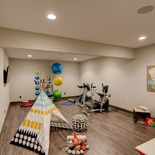 A children's playroom with toys and a teepee, located in a luxury custom home built by a custom home builder in Carmel, Indiana.