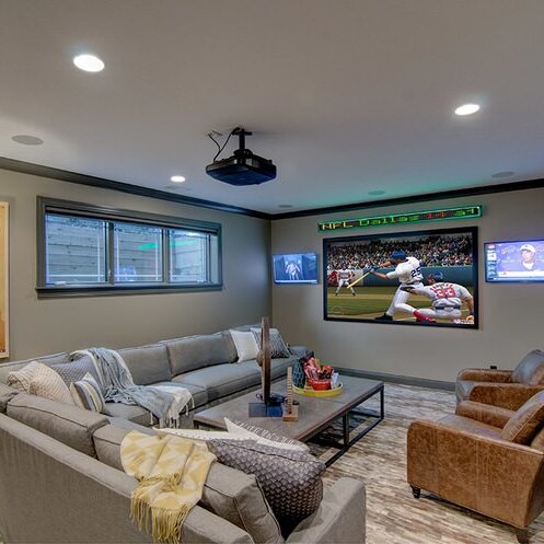 A living room with a flat screen tv, couch, and custom-built elements.