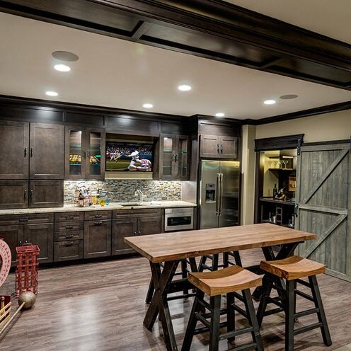 A kitchen with a bar and stools in it, perfect for Fishers Indiana Custom Homes.