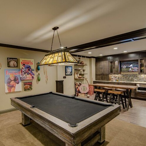 A luxurious game room featuring a pool table and a bar, designed by a top-notch custom home builder in Carmel Indiana.