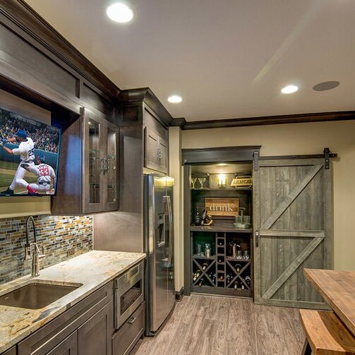 A kitchen with a tv mounted on the wall in a luxury custom home.