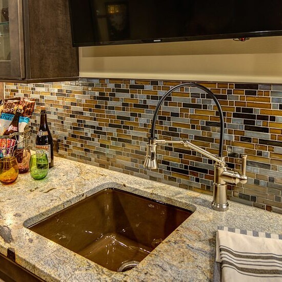 A kitchen with a sink and a TV, built by a Custom Home Builder in Carmel Indiana.