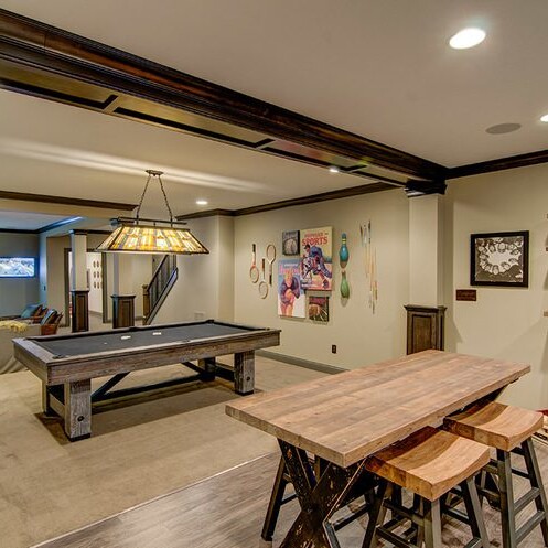 Fishers Indiana Custom Homes offers a game room with a pool table and bar stools, perfect for entertaining in your new home for sale in Carmel Indiana.