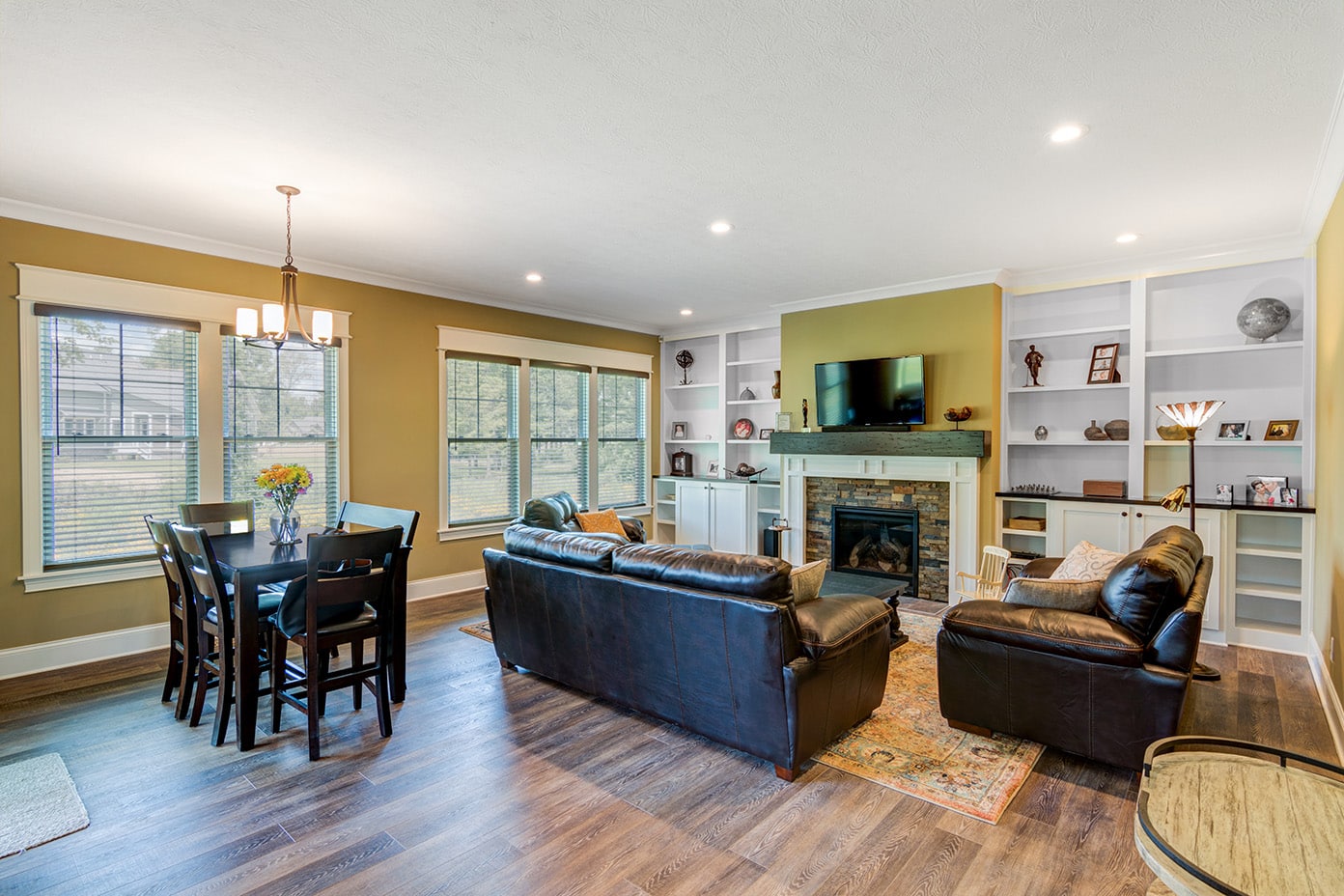 A living room with hardwood floors and a fireplace in a custom home.