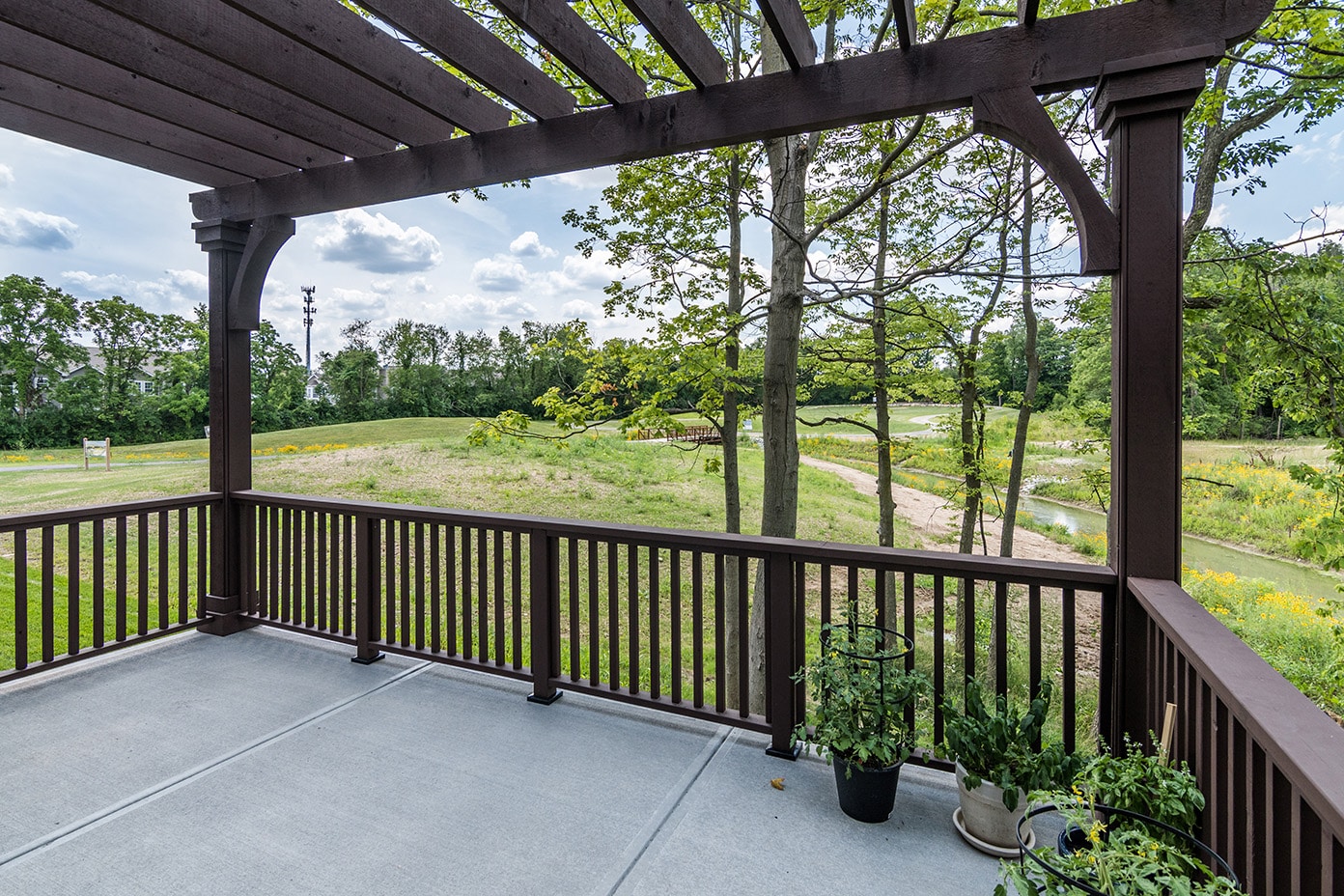 A wooden deck with a view of a golf course in Custom Homes Westfield Indiana.