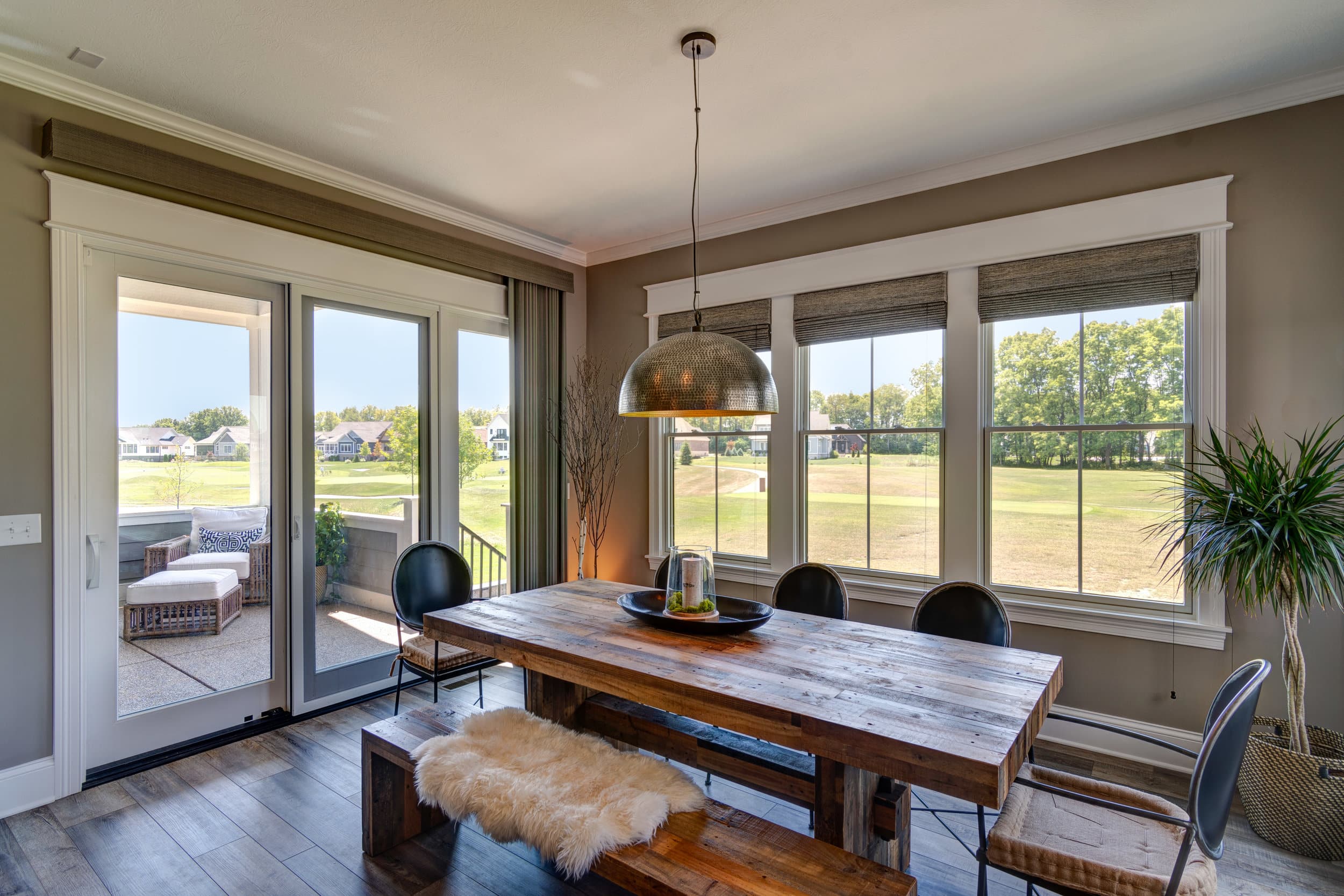 A dining room with hardwood floors and a sliding glass door in a custom home build by a Custom Home Builder Carmel Indiana.