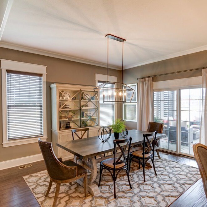 A dining room with a dining table and chairs in a luxury custom home.