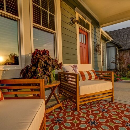 The front porch of a home in Westfield, Indiana has furniture and a rug.
