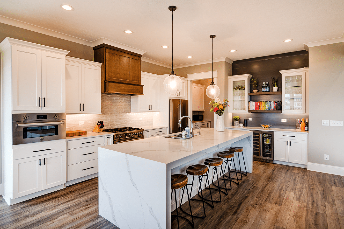A kitchen with white cabinets and a center island. Our custom home builder in Fishers, Indiana can create your dream kitchen with white cabinets and a stylish center island.