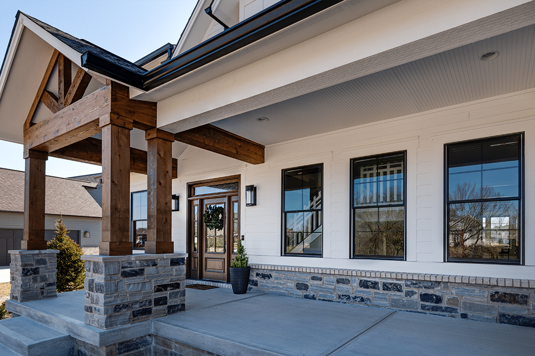 The front porch of a custom home with stone steps.