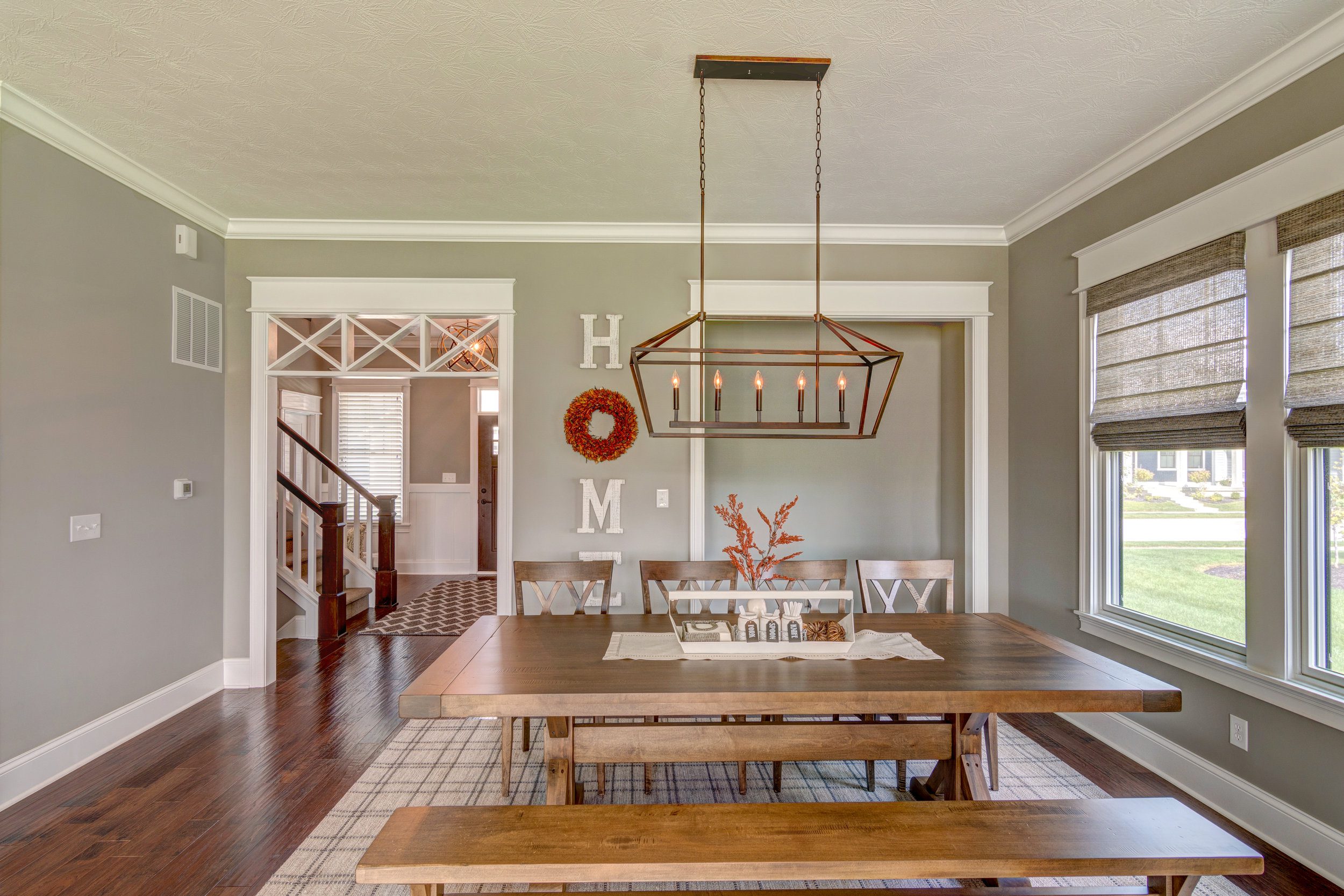 A dining room with a wooden table and chairs, designed and crafted by a custom home builder in Carmel, Indiana.
