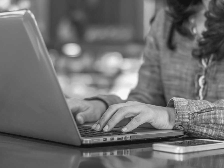 A woman is typing on a laptop computer.