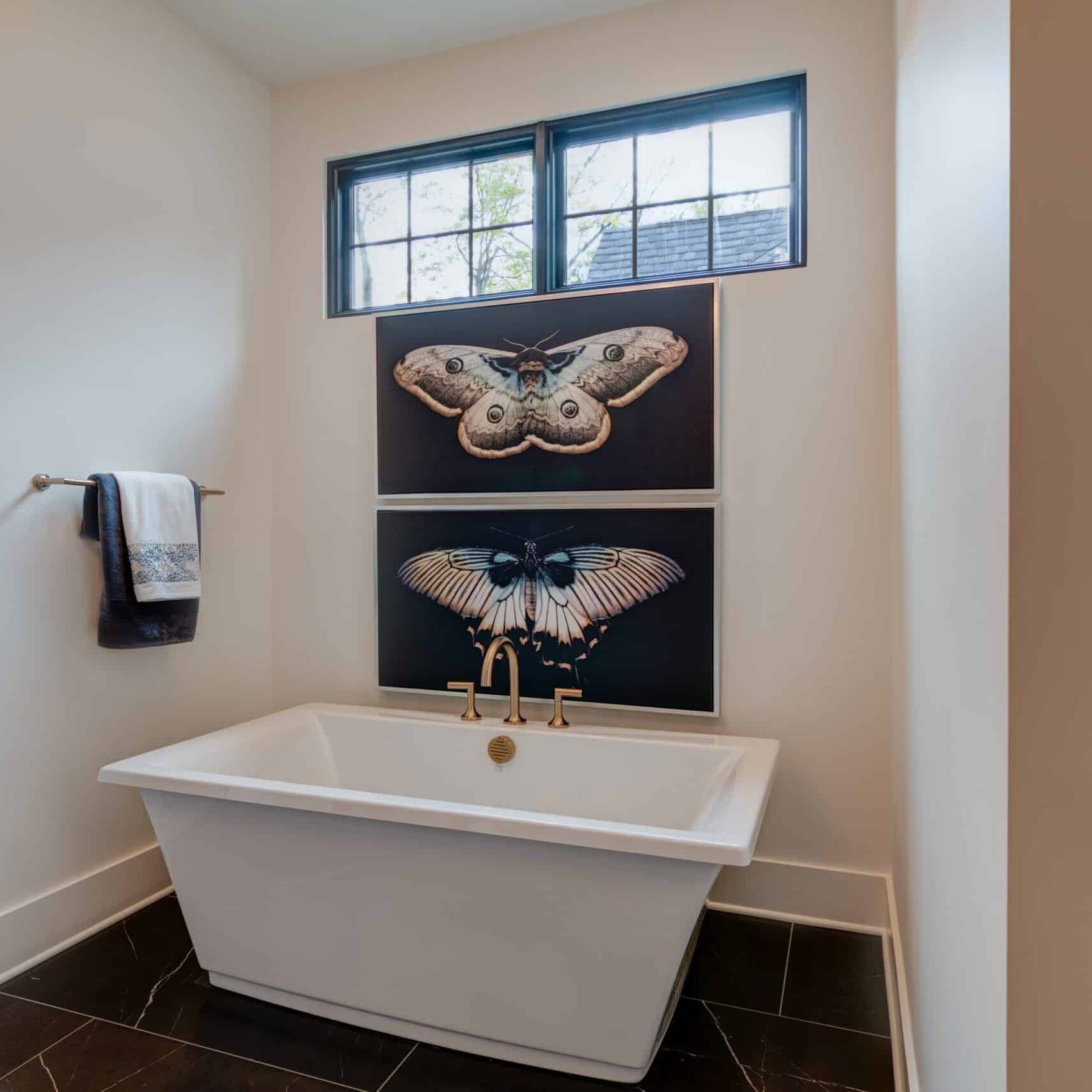 A bathroom with a white tub and black walls.