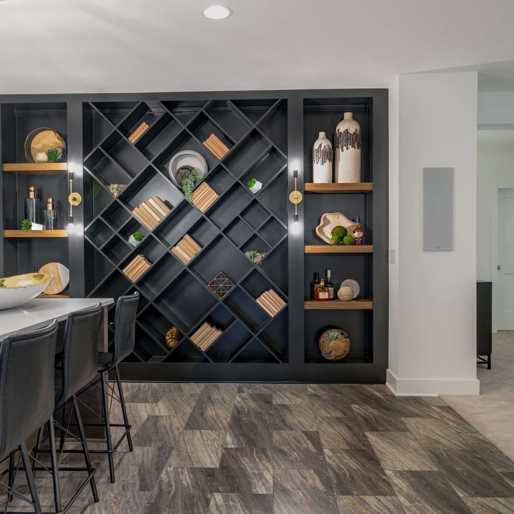 A kitchen with a black wine rack and stools.