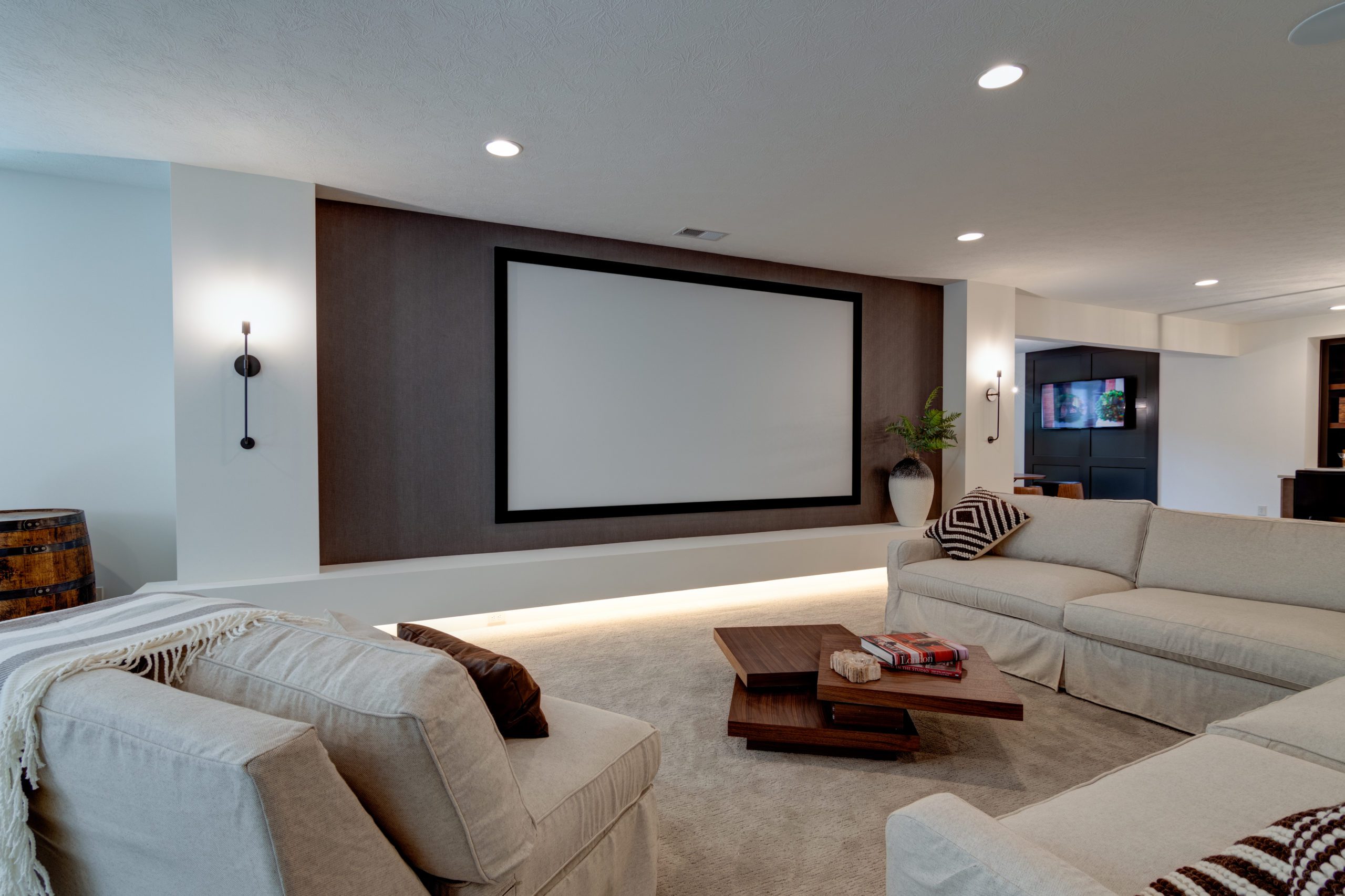 A living room with a large screen and couches.