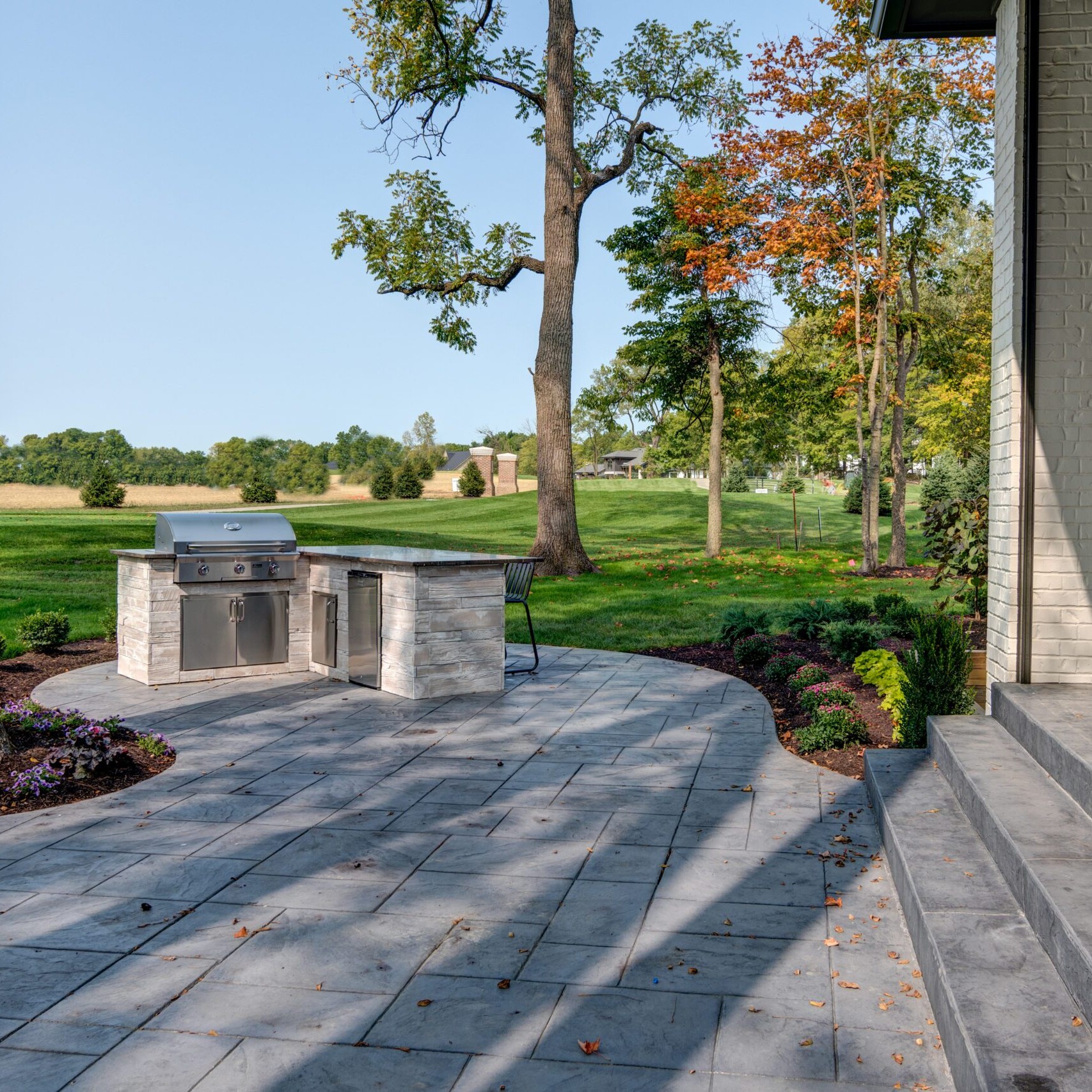 A patio with a grill and a fireplace.