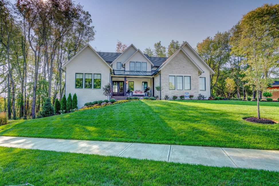 A beautiful home with a large lawn and trees.