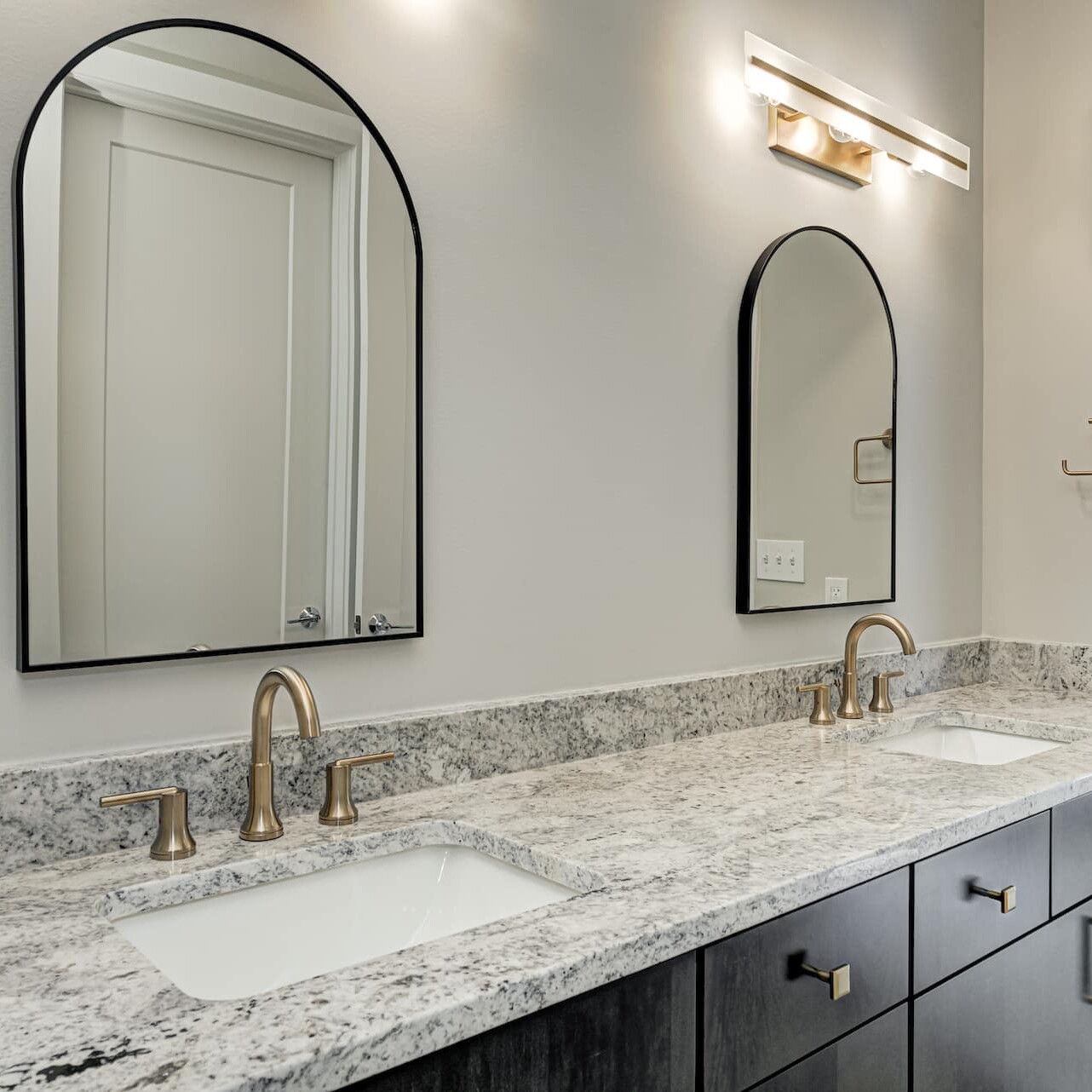 A bathroom with two sinks and a mirror, designed and built by a top-tier custom home builder in Carmel, Indiana.