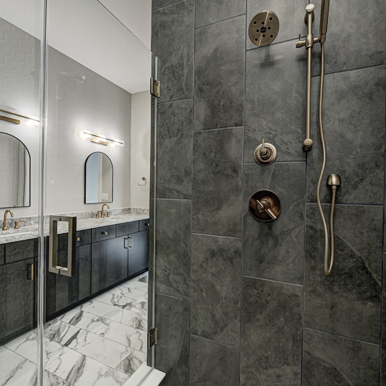 A modern bathroom with a marble shower stall in a custom home.