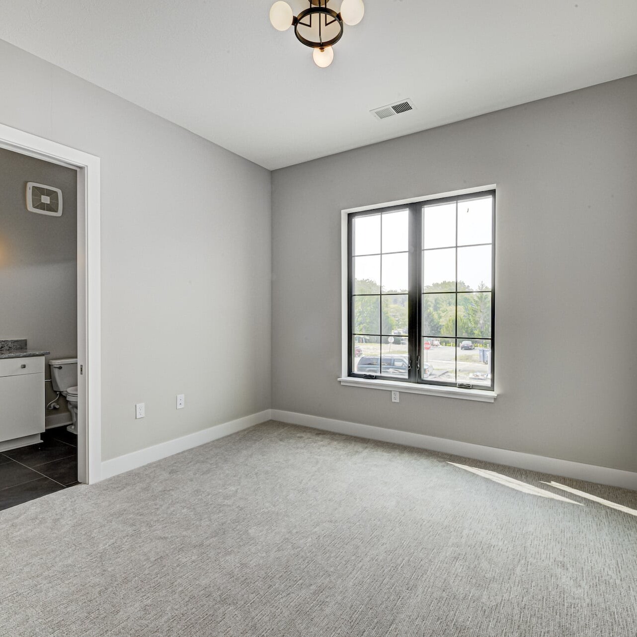 A gray bedroom with a window and a sink, perfect for those seeking custom homes or new homes in Carmel or Westfield, Indiana.