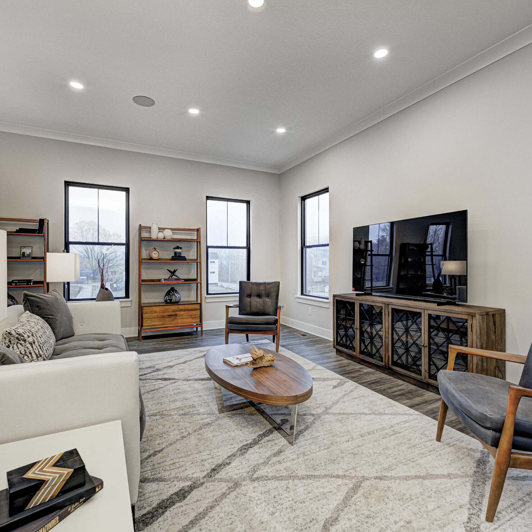 A living room with a custom-built couch and state-of-the-art TV in a newly constructed home.