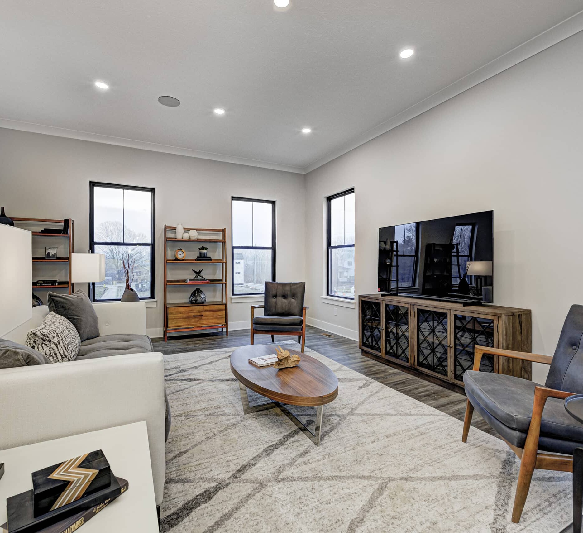 A living room with a custom-built couch and state-of-the-art TV in a newly constructed home.