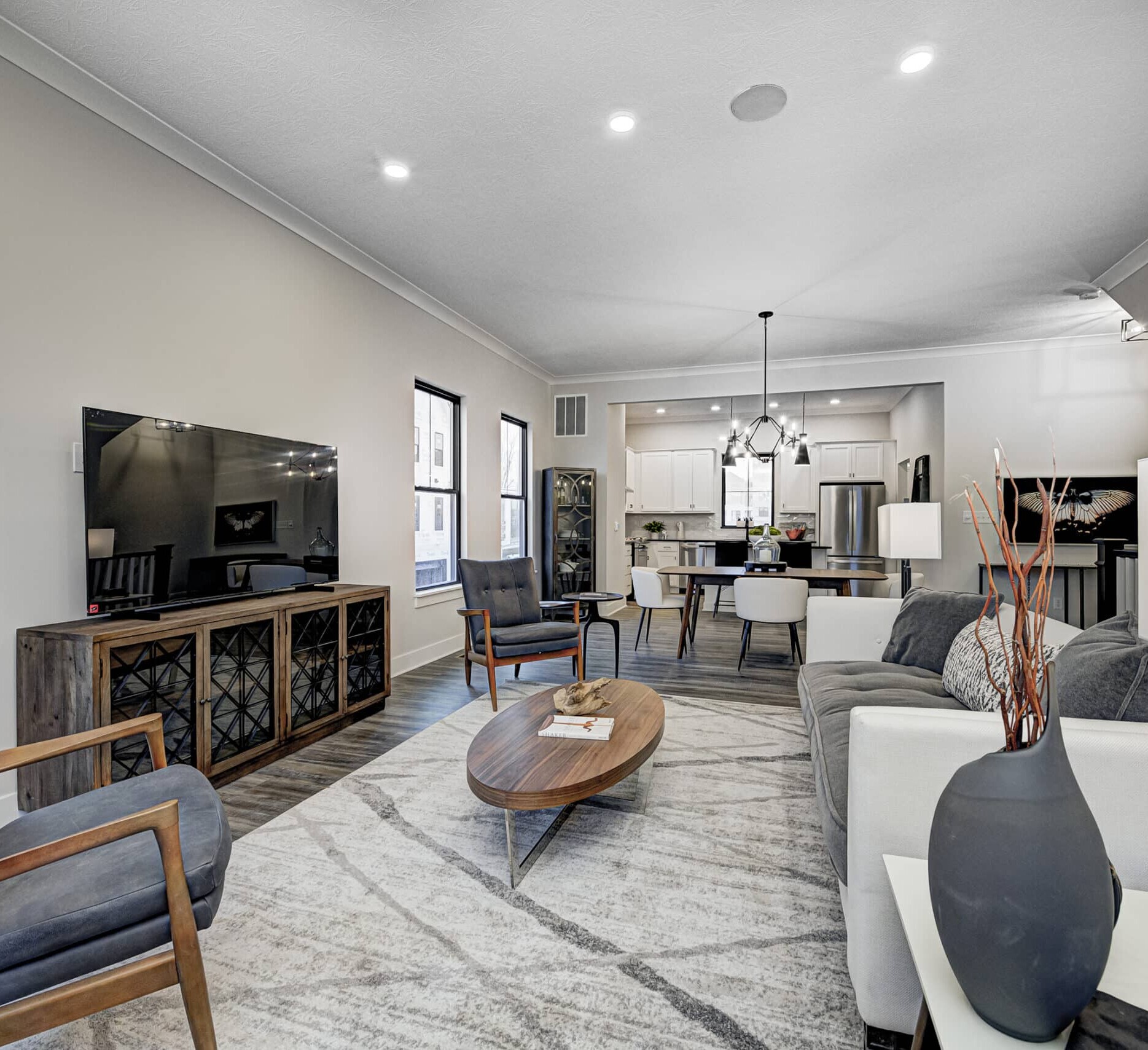 A living room adorned with beautiful hardwood floors and featuring a stylish TV, crafted by an exceptional Custom Home Builder in Carmel Indiana.