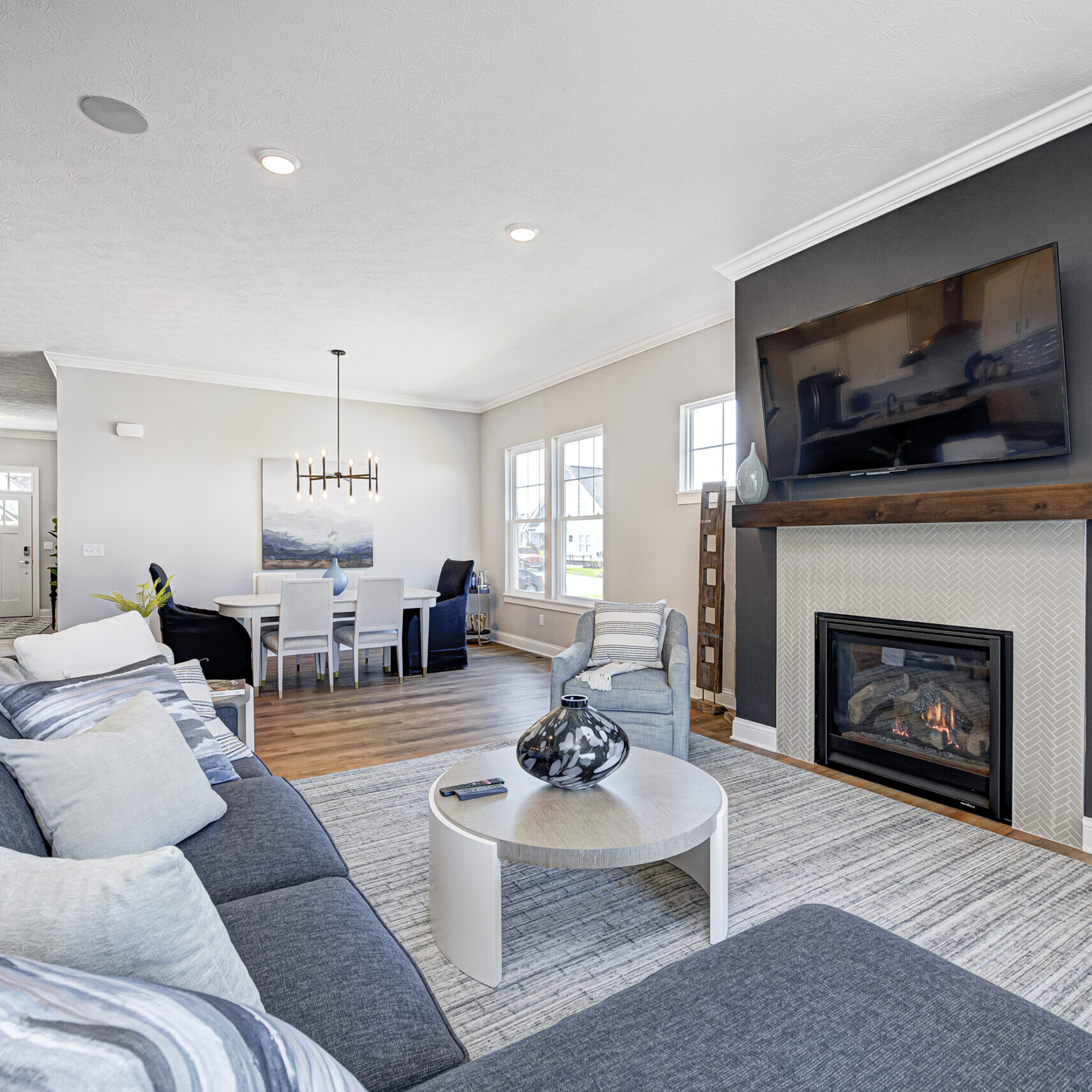 Looking for a new home in Carmel or Fishers, Indiana? Look no further! This stunning living room features a cozy fireplace and state-of-the-art TV.