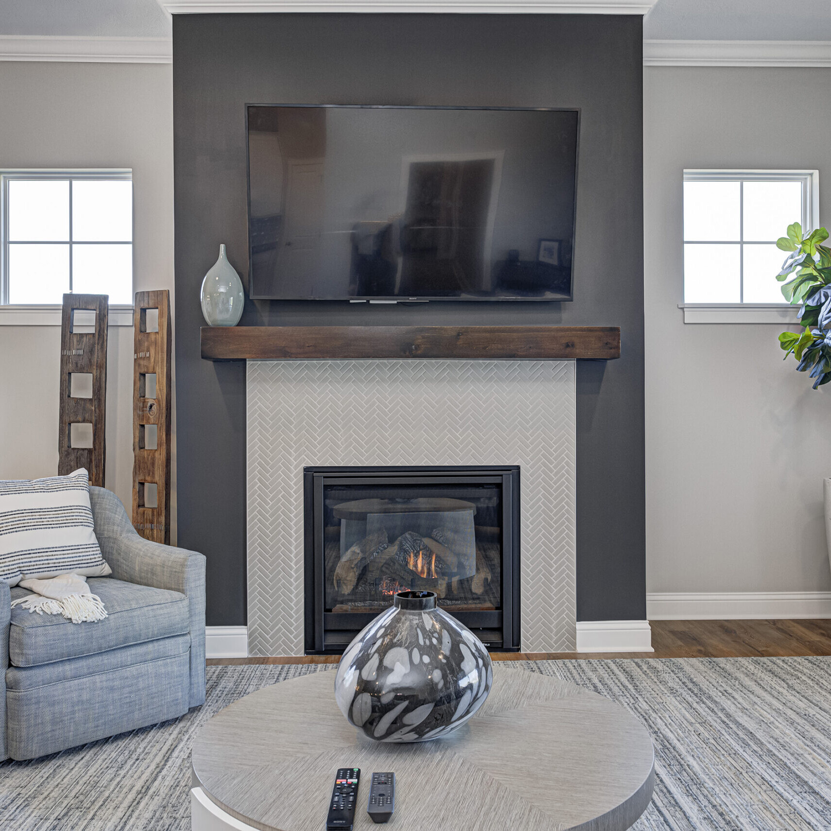 A living room with a tv above the fireplace in a Custom Home Builder Carmel Indiana.