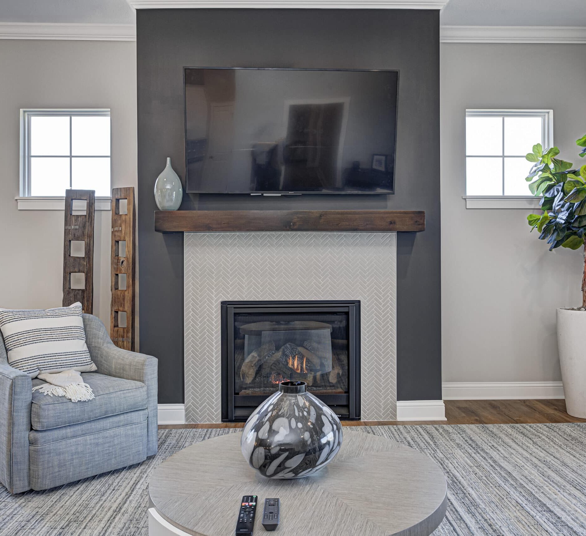 A living room with a tv above the fireplace in a Custom Home Builder Carmel Indiana.