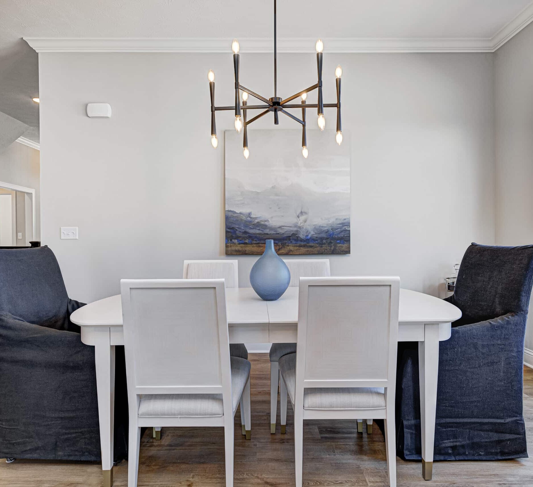 A dining room with a white table and chairs in a custom home.