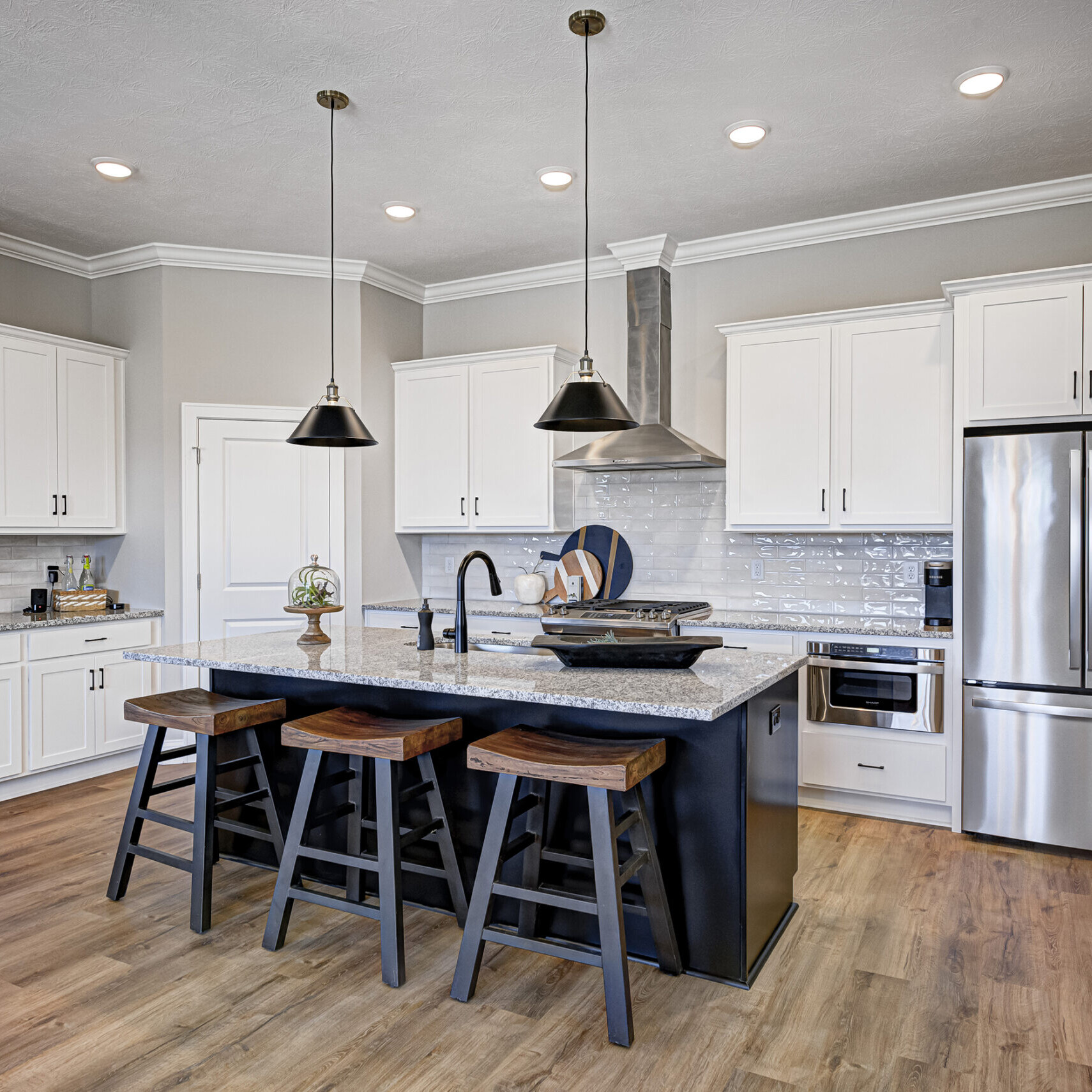 A kitchen with white cabinets and stainless steel appliances, the perfect addition to custom homes in Carmel Indiana.