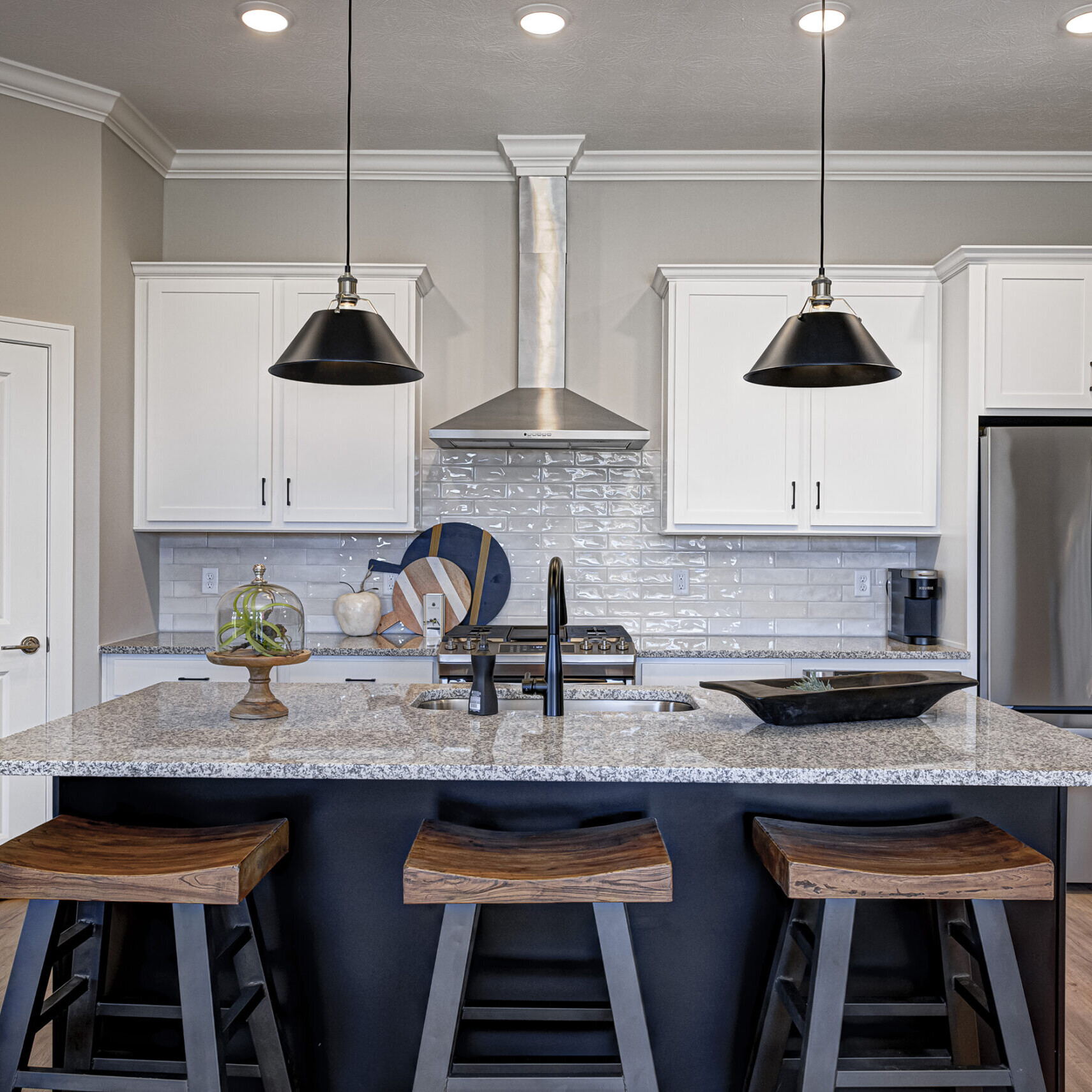 A kitchen with a center island and stools, custom-built by a reputable home builder in Indiana.
