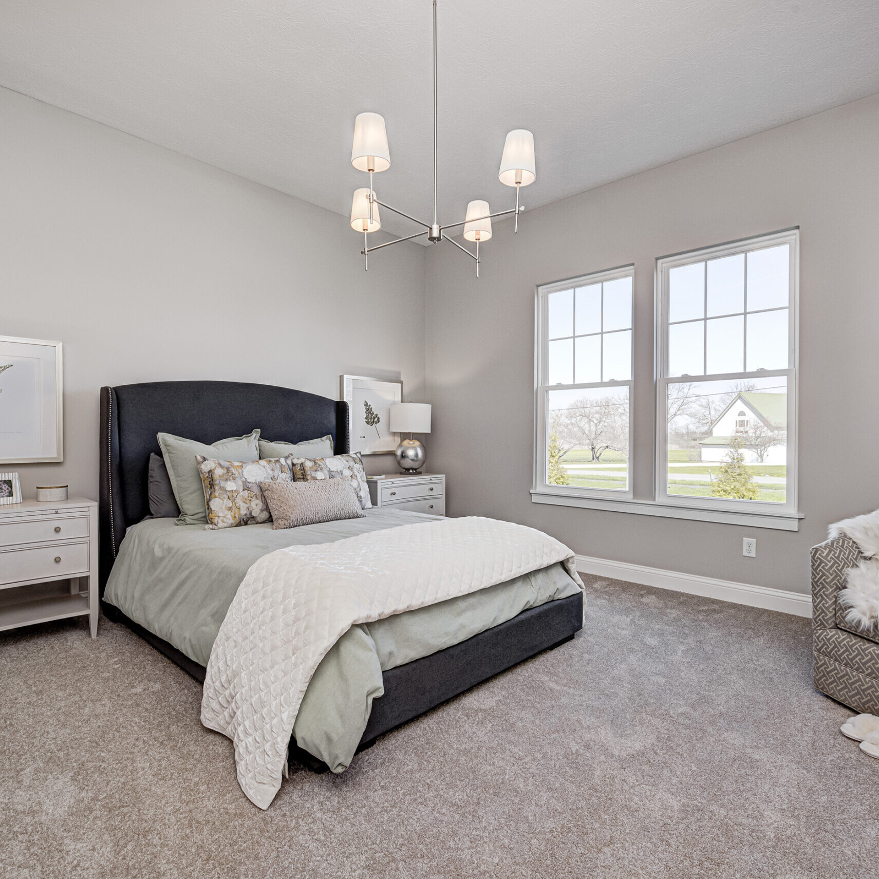 A bedroom with a bed and a dresser, designed by a custom home builder in Carmel Indiana.