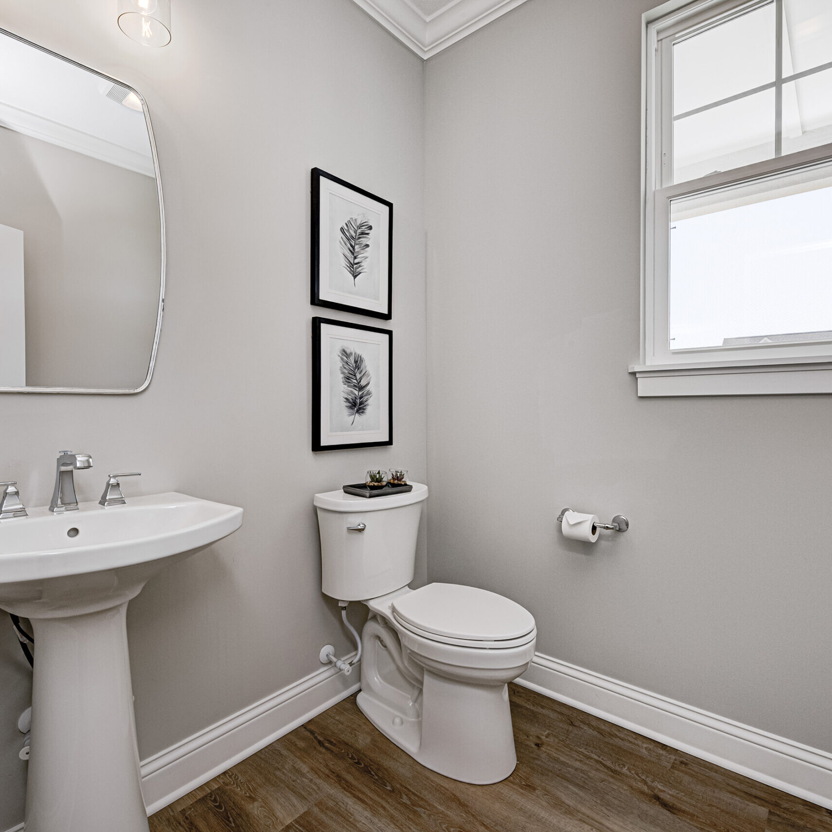 A custom bathroom with a toilet, sink, and window.